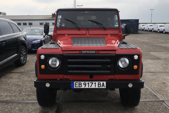 Front view of Gambler, a Rutland Red 1991 Land Rover Defender 90 with a black roof, our first restoration
