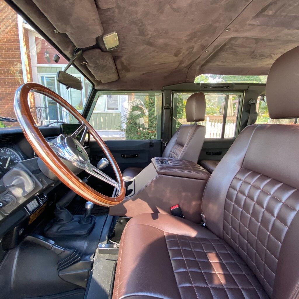 Front cabin of The Nomad with chocolate leather seats, wood steering wheel and Alcantara headliner