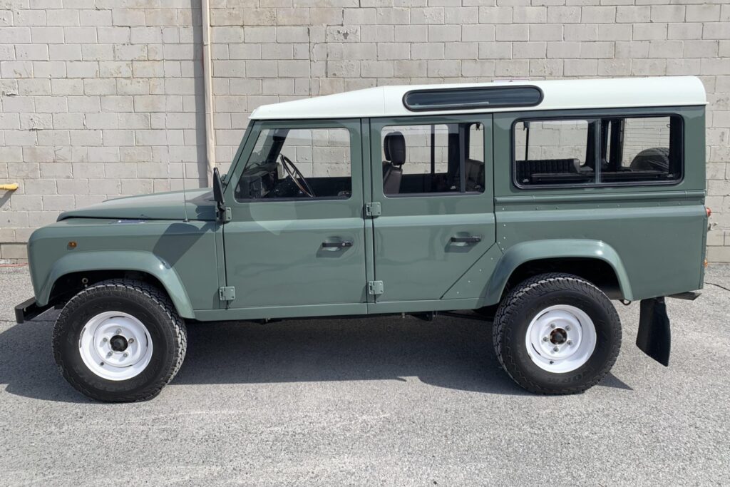 Left side profile of The Nomad, a Keswick Green Defender 110 Station Wagon with a white roof