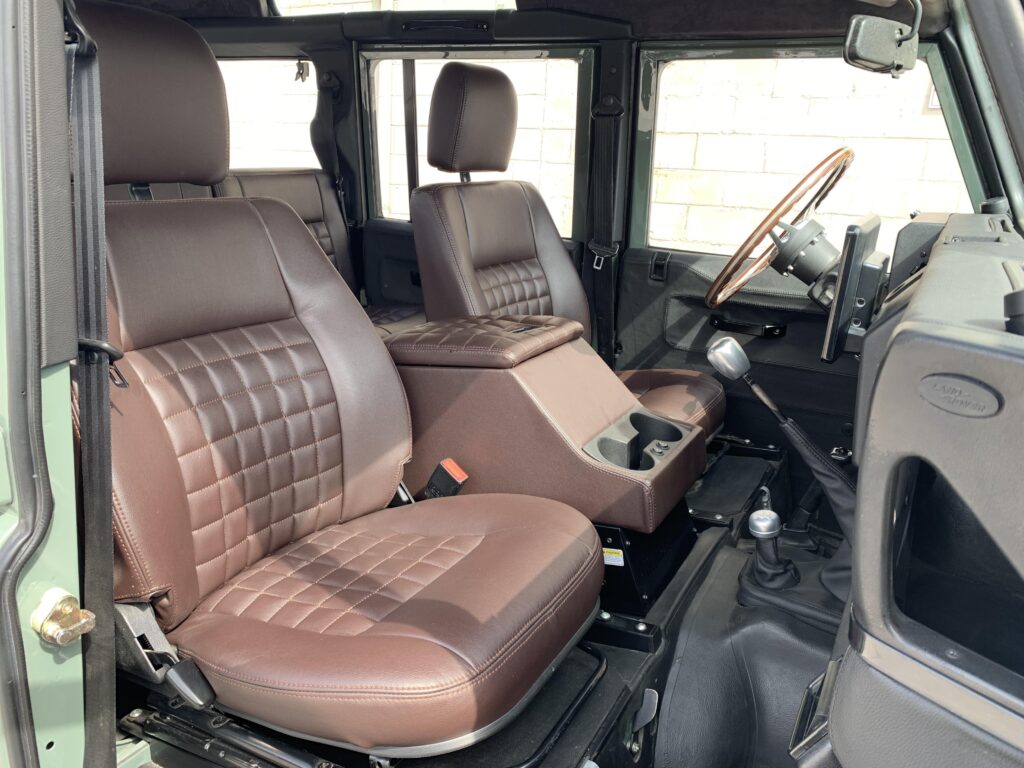 Chocolate square-stitched leather seats and cubby in The Nomad