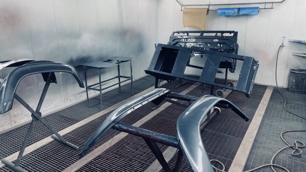 The Ninety's body panels laid out in the paint booth, painted piece by piece in Polymetal Grey metallic