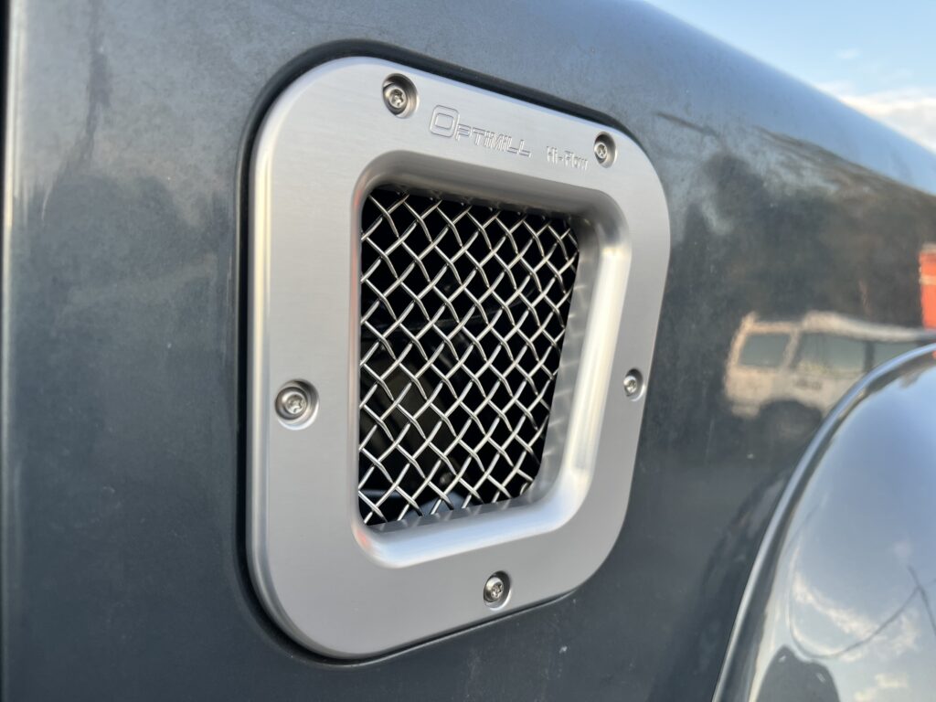 Optimill billet aluminum vent grille on the Ninety's Polymetal Grey wing