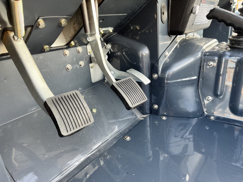 Pedals and footwell of the Ninety in Polymetal Grey, with restored plated hardware