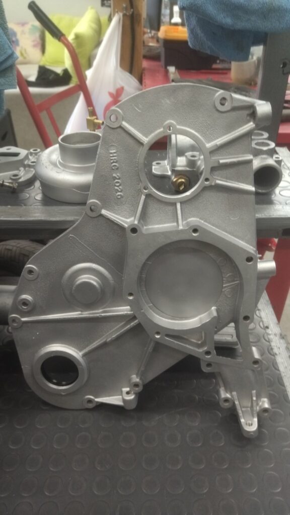 The 200Tdi's water-blasted aluminium timing cover, with the Garrett turbo housing behind