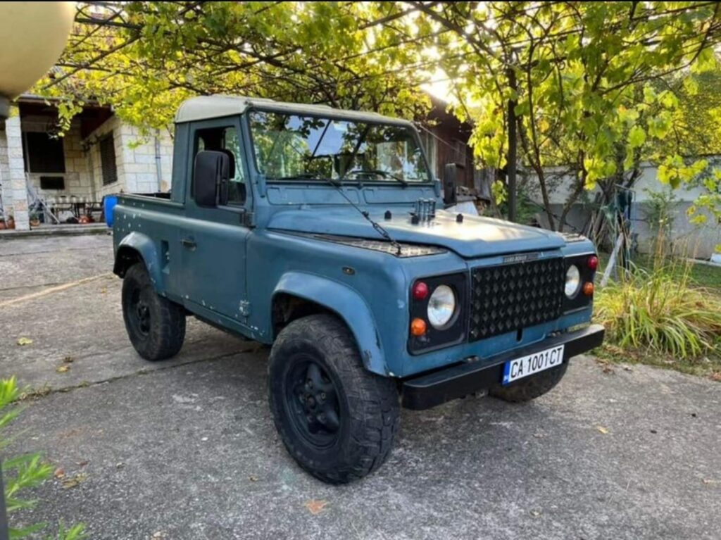 Barry, the blue Land Rover 90 pickup, parked under the trees before the teardown